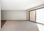 Thumbnail 8 of 14 - St. Louis Park, MN Courtyard Apartments. A bedroom with a carpeted floor and a sliding glass door to a balcony