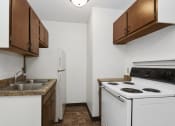 Thumbnail 5 of 9 - West St. Paul, MN Covington Courts Apartments. a kitchen with white appliances and brown cabinets