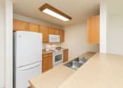 Thumbnail 4 of 21 - a kitchen with white appliances and wooden cabinets. Fargo, ND Sunrise North
