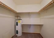 Thumbnail 9 of 10 - a closet with shelves and a water heater. Fargo, ND Dakota Manor Apartments