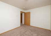 Thumbnail 9 of 11 - a room with a carpeted floor and a door to a closet. Fargo, ND Danbury Apartments