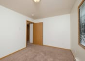 Thumbnail 7 of 11 - a bedroom with carpet and a door to a bedroom. Fargo, ND Danbury Apartments