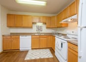 Thumbnail 4 of 11 - a kitchen with white appliances and wooden cabinets. Fargo, ND Danbury Apartments