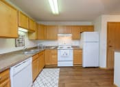 Thumbnail 5 of 11 - a kitchen with white appliances and wooden cabinets. Fargo, ND Danbury Apartments