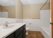 Thumbnail 16 of 29 - Anoka, MN Dellwood Estates Apartments. A bathroom with a toilet sink and bathtub