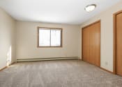 Thumbnail 11 of 29 - Anoka, MN Dellwood Estates Apartments. A bedroom with a window and a closet