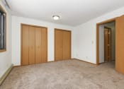 Thumbnail 23 of 29 - an empty living room with three doors and carpeting. Anoka, MN Dellwood Estates