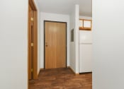 Thumbnail 24 of 29 - a hallway with a wooden door and a white refrigerator. Anoka, MN Dellwood Estates