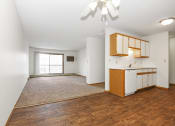 Thumbnail 21 of 29 - an empty living room and kitchen with wood flooring and a window .Anoka, MN Dellwood Estates