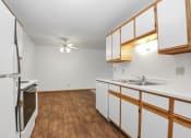 Thumbnail 19 of 29 - a kitchen with white cabinets and stainless steel appliances and a wood floor. Anoka, MN Dellwood Estates