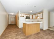 Thumbnail 15 of 29 - Anoka, MN Dellwood Estates Apartments. a kitchen with white appliances and wooden cabinets