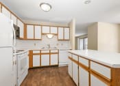 Thumbnail 14 of 29 - Anoka, MN Dellwood Estates Apartments. a kitchen with white cabinets and white countertops
