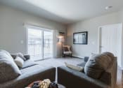 Thumbnail 3 of 11 - Bismarck, ND Diamond Bend Apartments. a living room with a couch and chair in front of a sliding glass door