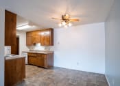 Thumbnail 17 of 25 - an empty kitchen and living room with a ceiling fan. Fargo, ND Betty Ann Apartments