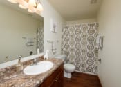Thumbnail 12 of 12 - a bathroom with a sink and a toilet and a shower. Fargo, ND Dynasty Apartments