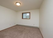 Thumbnail 8 of 12 - a bedroom with carpet and a window. Fargo, ND Dynasty Apartments