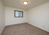 Thumbnail 10 of 12 - a bedroom with carpet and a window. Fargo, ND Dynasty Apartments