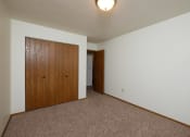 Thumbnail 9 of 12 - a bedroom with carpet and a door to a closet. Fargo, ND Dynasty Apartments