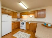 Thumbnail 6 of 12 - a kitchen with white appliances and wooden cabinets. Fargo, ND Dynasty Apartments