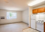 Thumbnail 33 of 42 - an empty kitchen with white appliances and a window.  Eagan, MN Glen Pond Apartments
