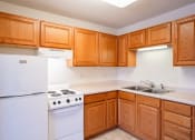 Thumbnail 34 of 42 - a kitchen with white appliances and wooden cabinets.  Eagan, MN Glen Pond Apartments