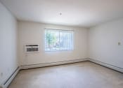 Thumbnail 32 of 42 - the living room of an empty house with a window and white walls. Eagan, MN Glen Pond Apartments