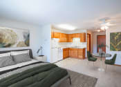 Thumbnail 12 of 42 - a bedroom with a bed and a kitchen with a table and chairs