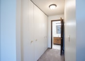 Thumbnail 30 of 42 - a hallway with white cabinets and a bathroom with a mirror.  Eagan, MN Glen Pond Apartments