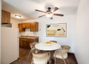 Thumbnail 3 of 42 - a dining area with a table and chairs and a kitchen with a refrigerator. Eagan, MN Glen Pond Apartments