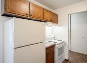 Thumbnail 26 of 42 - a kitchen with white appliances and wooden cabinets and a refrigerator.  Eagan, MN Glen Pond Apartments