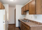 Thumbnail 15 of 42 - a kitchen with wooden cabinets and a sink and a refrigerator. Eagan, MN Glen Pond Apartments