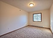 Thumbnail 10 of 28 - A bedroom with white walls and a window. Fargo, ND Eagle Run Apartments.