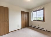 Thumbnail 12 of 14 - Bismarck, ND Eagle Sky I Apartments. A bedroom with a window and a door