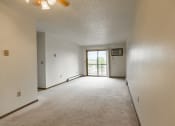 Thumbnail 8 of 14 - Bismarck, ND Eagle Sky I Apartments. A living room and dining room with a glass sliding door.