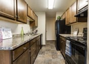 Thumbnail 6 of 14 - Bismarck, ND Eagle Sky I Apartments. A kitchen with black appliances