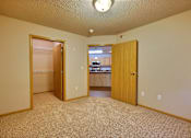 Thumbnail 11 of 12 - a bedroom with a door open to a closet. Fargo, ND East Bridge Apartments