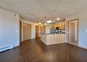 Thumbnail 7 of 12 - a living room and kitchen with wood floors. Fargo, ND East Bridge Apartments