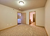 Thumbnail 9 of 12 - a bedroom with a door to a bathroom. Fargo, ND East Bridge Apartments