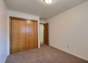 Thumbnail 9 of 12 - a bedroom with a closet and carpeted floors. Fargo, ND Emerald Apartments