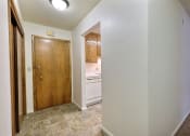 Thumbnail 10 of 12 - the view of the kitchen from the living room with a wooden door. Fargo, ND Emerald Apartments
