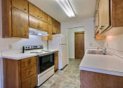 Thumbnail 8 of 12 - a kitchen with white appliances and wooden cabinets. Fargo, ND Emerald Apartments