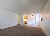 Thumbnail 7 of 12 - a living room with a kitchen and dining room in the background. Fargo, ND Emerald Apartments