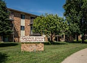 Thumbnail 8 of 9 - A brick building with a sign that says Garden Grove Apartments. Bismarck, ND Garden Grove Apartments