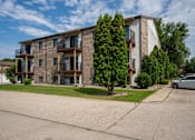 Thumbnail 10 of 10 - A large apartment building with balconies and trees in front. Fargo, ND Hawthorn Apartments