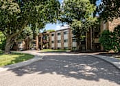 Thumbnail 11 of 13 - A tree-lined street with a building in the background. White Bear Lake, MN White Bear Terrace Apartments