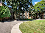 Thumbnail 13 of 13 - A tree-lined street in front of a brick building. White Bear Lake, MN White Bear Terrace Apartments