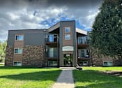 Thumbnail 14 of 17 - a modern building named Cedarwood with a signboard and a walkway leading to the entrance. Grand Forks, ND Cedarwood Apartments