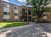 Thumbnail 12 of 13 - A large apartment complex with a tree in front. White Bear Lake, MN White Bear Terrace Apartments