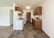 Thumbnail 17 of 34 - a kitchen with white appliances and wooden cabinets. Fargo, ND Islander Apartments