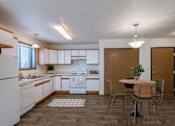 Thumbnail 5 of 28 - a kitchen and dining room with a table and chairs. Fargo, ND Eagle Run Apartments